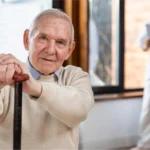 Senior man doing light exercise indoors.