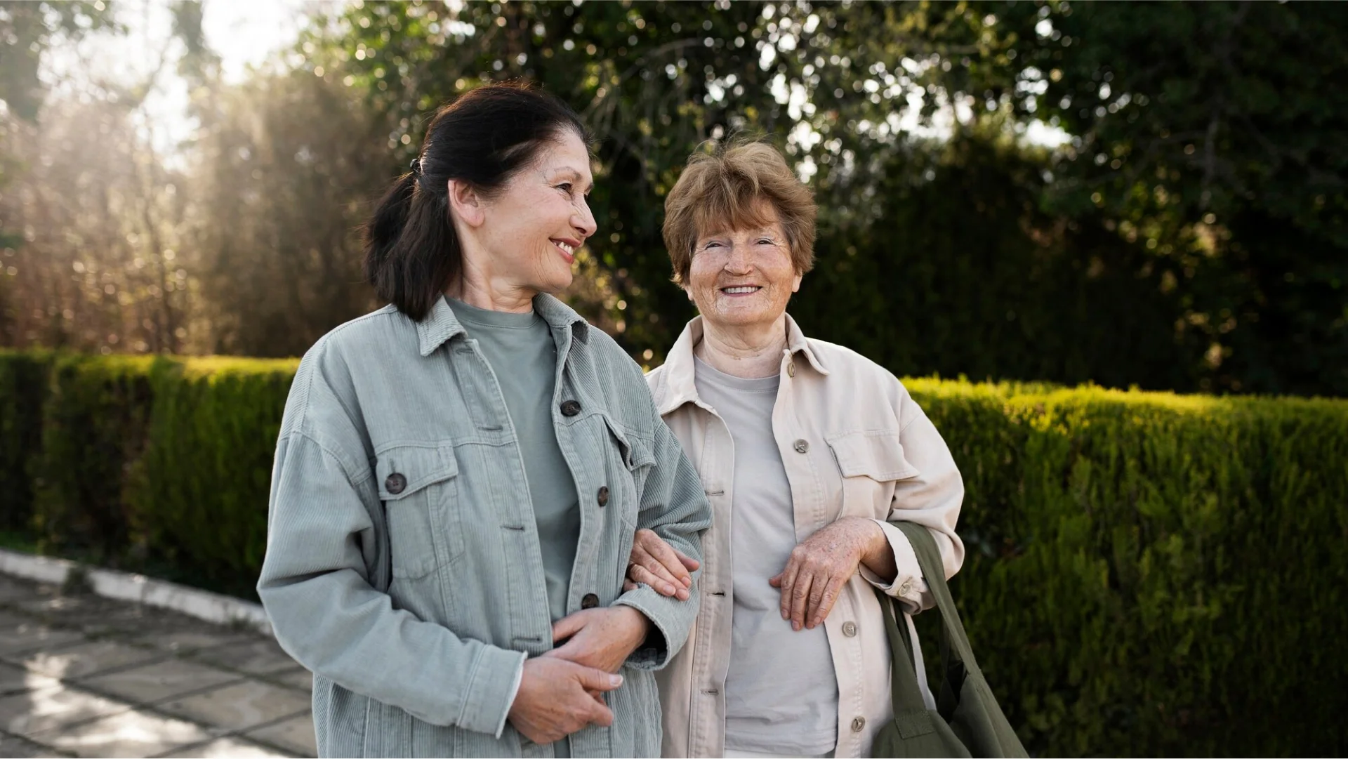 Two young women walking arm in arm outdoors.