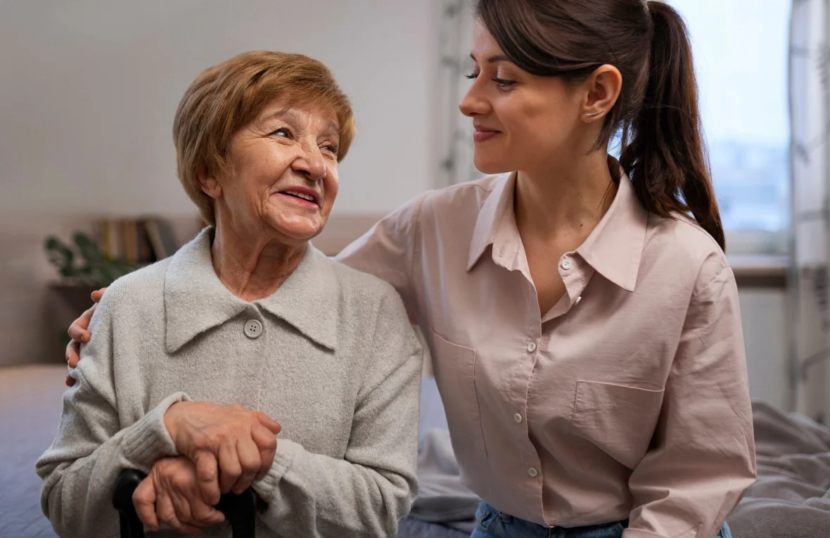 Caregiver reassuring an elderly woman indoors.