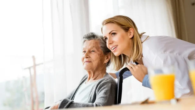 Woman reassuring senior with hand on shoulder.