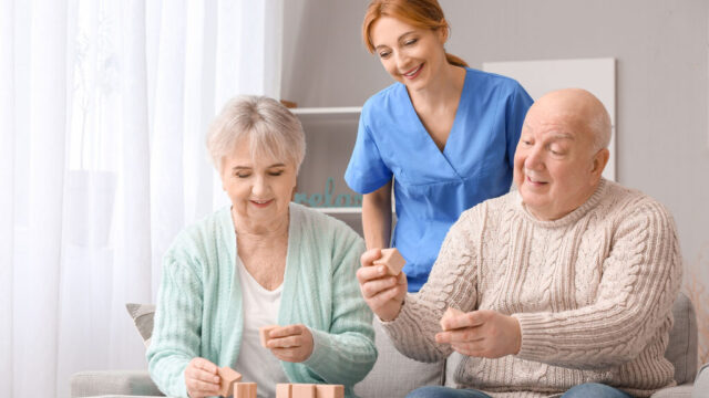 Caregiver helping older adults in a group discussion.
