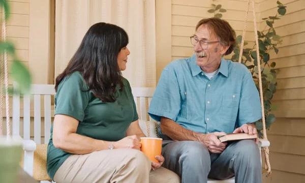 The caregiver having a friendly chat with an old man over coffee.