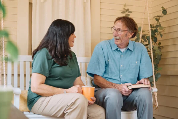 The caregiver having a friendly chat with an old man over coffee.