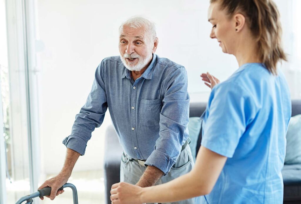 Physiotherapist helping senior man for walking