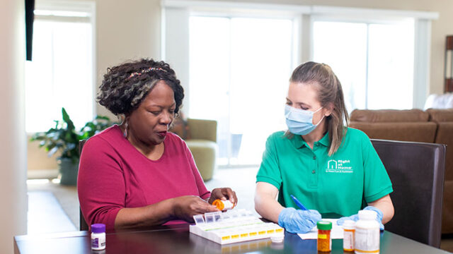 Nurse chatting with senior in a bright room.