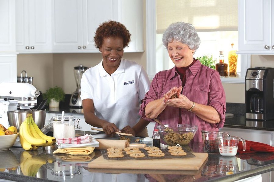 Two women baking together in a modern kitchen.