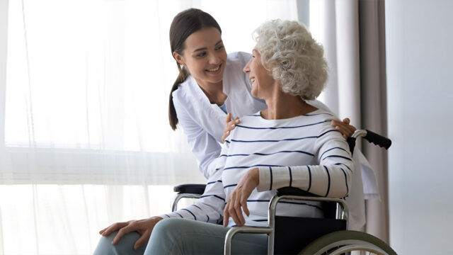 Woman hugging her grandmother in a wheelchair.